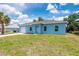Single-story blue home featuring an attached garage and landscaped front yard at 21480 Eldred Ave, Port Charlotte, FL 33952