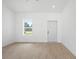 Bright living room featuring wood-look tile floors, fresh white paint and ample natural light at 21480 Eldred Ave, Port Charlotte, FL 33952