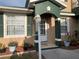Charming front door and entry with green trim and matching potted plants at 224 Boundary Blvd # 224L, Rotonda West, FL 33947