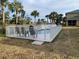 Relaxing pool setting with a safety fence, palm trees, and lawn chairs for ultimate enjoyment at 224 Boundary Blvd # 224L, Rotonda West, FL 33947
