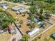 Aerial view of a large, fenced yard showcasing lush landscaping, sheds, and a charming play area at 2411 Atwater Dr, North Port, FL 34288
