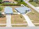An aerial view showcasing the home's layout, long driveway, and spacious yard surrounded by lush landscaping at 2411 Atwater Dr, North Port, FL 34288