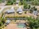 Aerial view of the property, revealing mature landscaping, nearby neighborhood pools, and surrounding community at 2411 Atwater Dr, North Port, FL 34288