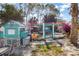 Backyard with chicken coop, a unique play area, and tropical foliage, creating a charming outdoor space at 2411 Atwater Dr, North Port, FL 34288