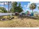 Backyard with tropical landscaping features mature trees, flowers, a chicken coop and a fenced perimeter at 2411 Atwater Dr, North Port, FL 34288