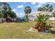 Landscaped backyard features Adirondack chairs with an umbrella, stone landscaping and a chicken coop at 2411 Atwater Dr, North Port, FL 34288