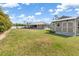 View of the large grass backyard featuring a utility shed and the main home with a fenced perimeter at 2411 Atwater Dr, North Port, FL 34288