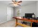 Cozy bedroom with plush carpet, grey walls, window, and wooden desk, complete with a sleek monitor at 2411 Atwater Dr, North Port, FL 34288