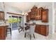 Dining area has a glass table and chairs, custom cabinets, and a sliding door to the outdoor lanai at 2411 Atwater Dr, North Port, FL 34288