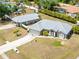 Inviting gray home featuring a metal roof, landscaped yard, and a long driveway leading to an attached garage at 2411 Atwater Dr, North Port, FL 34288