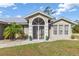 Inviting front entrance with decorative security door, lush landscaping, and a well-maintained lawn at 2411 Atwater Dr, North Port, FL 34288