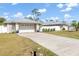 A beautiful garage with an extended driveway and lush lawn, perfectly capturing the serene curb appeal at 2411 Atwater Dr, North Port, FL 34288
