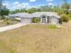 A charming exterior with a well-manicured lawn, grey metal roof, and ample parking space in the driveway at 2411 Atwater Dr, North Port, FL 34288
