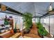 Well-lit greenhouse features vegetable plants, gardening tools and shelving units with wood chip flooring at 2411 Atwater Dr, North Port, FL 34288