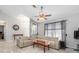 Bright living room features tile floors, vaulted ceilings, a ceiling fan, and a comfortable, modern leather sectional at 2411 Atwater Dr, North Port, FL 34288