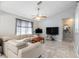 Bright living room features tile floors, vaulted ceilings, a ceiling fan, and a comfortable, modern leather sectional at 2411 Atwater Dr, North Port, FL 34288