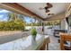 Enclosed patio featuring an outdoor dining area with ceiling fans and a scenic view of the backyard at 2411 Atwater Dr, North Port, FL 34288