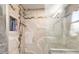 Close up of the renovated shower with custom tile, storage niche, and glass door at 2411 Atwater Dr, North Port, FL 34288