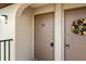 Close-up of tan unit entrance doors, one decorated with a colorful floral wreath at 25100 Sandhill Blvd # R201, Punta Gorda, FL 33983