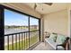 Screened lanai with comfortable seating and tranquil views of the pond and manicured lawns at 25100 Sandhill Blvd # R201, Punta Gorda, FL 33983