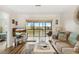 Cozy living room with wood floors and sliding glass doors to a screened balcony with lake view at 25100 Sandhill Blvd # R201, Punta Gorda, FL 33983