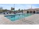 Community pool with a metal ladder entry with lounge chairs and pool house in background at 25100 Sandhill Blvd # R201, Punta Gorda, FL 33983