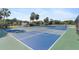 Community tennis courts in blues and greens surrounded by a chain link fence at 25100 Sandhill Blvd # R201, Punta Gorda, FL 33983