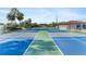 Well maintained community tennis courts with fence, palm trees and view of adjacent building at 25100 Sandhill Blvd # R201, Punta Gorda, FL 33983