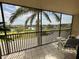 Relaxing screened balcony with seating and views of the palm trees and water at 25188 Marion Ave # F304, Punta Gorda, FL 33950