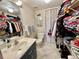 Well-lit bathroom with a sink, toilet, and a walk-in closet filled with clothes and accessories at 25188 Marion Ave # F304, Punta Gorda, FL 33950