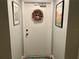Condo entrance featuring a white door adorned with a decorative wreath and unit number 304 at 25188 Marion Ave # F304, Punta Gorda, FL 33950