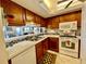 Charming kitchen showcasing wooden cabinets, white appliances, and a decorative backsplash at 25188 Marion Ave # F304, Punta Gorda, FL 33950