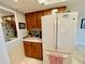 Functional kitchen corner highlighting ample cabinet space and a full-size white refrigerator at 25188 Marion Ave # F304, Punta Gorda, FL 33950