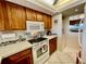 Well-equipped kitchen with wooden cabinetry, modern white appliances, and stylish checkerboard accents at 25188 Marion Ave # F304, Punta Gorda, FL 33950