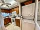 Efficient kitchen featuring stacked washer/dryer units and white appliances at 25188 Marion Ave # F304, Punta Gorda, FL 33950