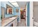 Bathroom with long vanity and cabinet storage with walk-in closet access at 26461 Explorer Rd # F, Punta Gorda, FL 33983