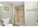 Bathroom with toilet, towel bar, framed art, and glass enclosed walk-in shower at 26461 Explorer Rd # F, Punta Gorda, FL 33983