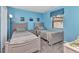 Comfortable bedroom with twin beds, gray furniture, beach decor, and a bright window at 26461 Explorer Rd # F, Punta Gorda, FL 33983