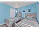 Charming bedroom featuring two twin beds, stylish linens, beach themed decor, and a bright window at 26461 Explorer Rd # F, Punta Gorda, FL 33983