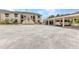 Unit's exterior featuring covered parking, assigned parking spaces, and walkway to the front door at 26461 Explorer Rd # F, Punta Gorda, FL 33983