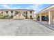 Unit's exterior showcasing assigned carport parking, well-maintained landscape, and easy access to front door at 26461 Explorer Rd # F, Punta Gorda, FL 33983
