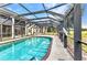 A beautiful pool with a screened in metal frame is located in a sunny yard at 26461 Explorer Rd # F, Punta Gorda, FL 33983