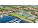Panoramic aerial showcasing the community with waterfront access, boat docks, tennis court, and manicured lawns at 303 11Th E Ave, Palmetto, FL 34221