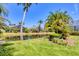 Scenic backyard view overlooking a tranquil pond and lush tropical landscaping at 303 11Th E Ave, Palmetto, FL 34221