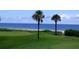 Scenic view of a golf course overlooking a beach with palm trees and vibrant green grass at 303 11Th E Ave, Palmetto, FL 34221