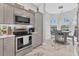 Well-appointed kitchen with gray cabinetry and stainless steel appliances next to an eat-in kitchen area at 303 11Th E Ave, Palmetto, FL 34221