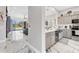 Modern kitchen featuring stainless appliances, gray cabinets and marble floors leading to the living area at 303 11Th E Ave, Palmetto, FL 34221