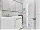 Laundry room with upper cabinets, white washer and dryer, and marble floors at 303 11Th E Ave, Palmetto, FL 34221