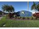 Community entrance sign set amidst manicured landscaping and tropical palm trees at 303 11Th E Ave, Palmetto, FL 34221