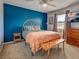 Modern bedroom with a blue accent wall, stylish bench, a ceiling fan, and patterned bedding at 4097 Rose Arbor Cir, Port Charlotte, FL 33948